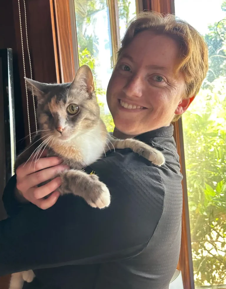 Catherine with one of her cats on her shoulder.